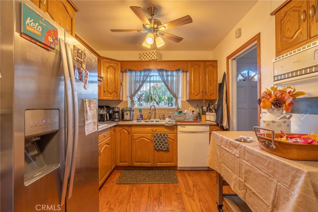 9920 Broadway Temple City, CA 91780 - Photo 5 of 26 a kitchen with stainless steel appliances granite countertop a refrigerator a sink dishwasher a stove and white countertops with wooden floor
