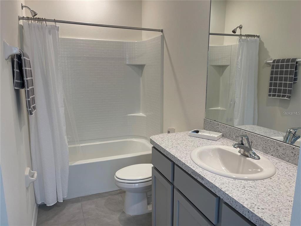 9011 Milestone Drive Sarasota, FL 34238 - Photo 20 of 32 a bathroom with a granite countertop sink toilet and shower