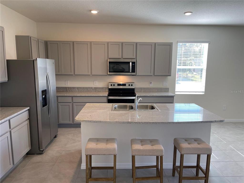 9011 Milestone Drive Sarasota, FL 34238 - Photo 4 of 32 a kitchen with a refrigerator and a stove top oven