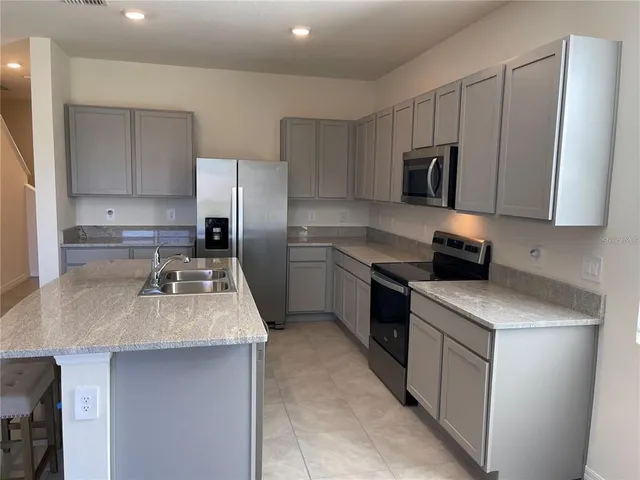 a view of kitchen with sink stainless steel appliances and cabinets