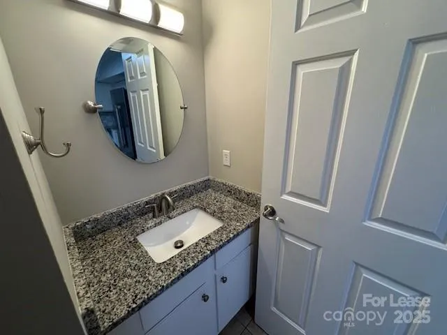 a bathroom with a granite countertop sink and mirror