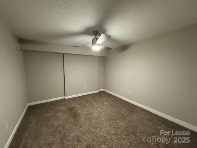 an empty room with an empty space and a ceiling fan
