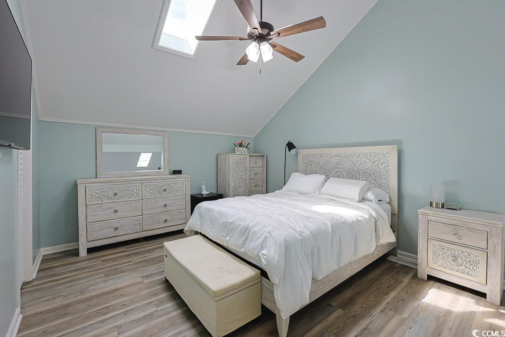 3700 Golf Colony Lane, Unit 5B Little River, SC 29566 - Photo 11 of 27 Bedroom featuring a skylight, light wood-style floors, a ceiling fan, and high vaulted ceiling
