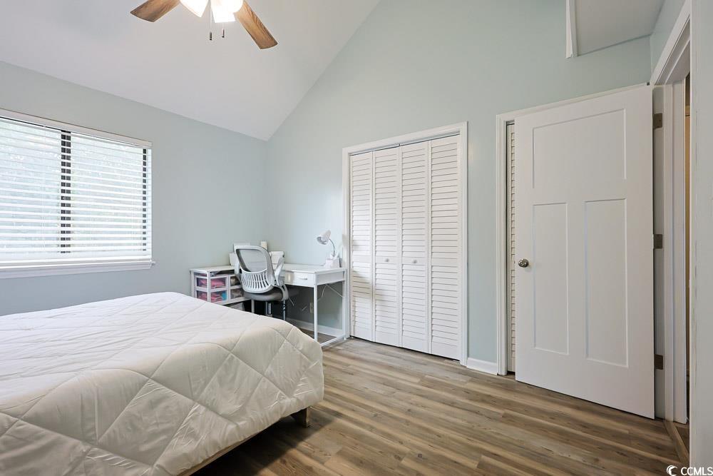 3700 Golf Colony Lane, Unit 5B Little River, SC 29566 - Photo 17 of 27 Bedroom featuring wood finished floors, a closet, high vaulted ceiling, and ceiling fan