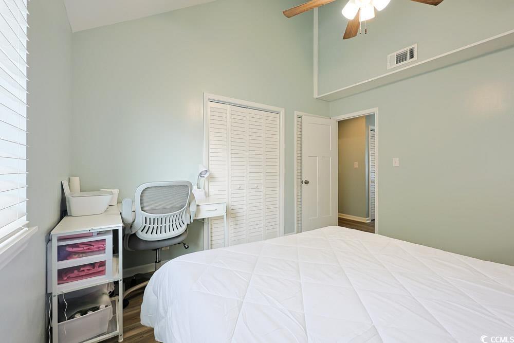 3700 Golf Colony Lane, Unit 5B Little River, SC 29566 - Photo 18 of 27 Bedroom with ceiling fan, high vaulted ceiling, a closet, and wood finished floors
