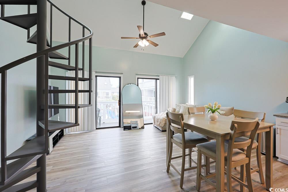 3700 Golf Colony Lane, Unit 5B Little River, SC 29566 - Photo 3 of 27 Dining room with high vaulted ceiling, light wood finished floors, ceiling fan, and stairs