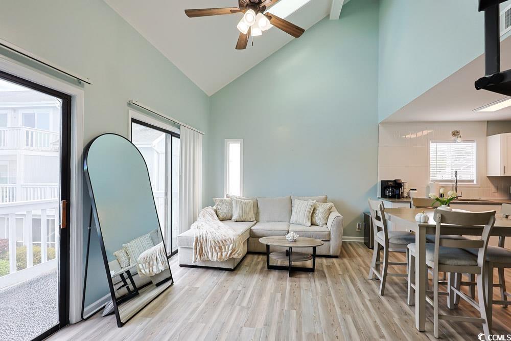 3700 Golf Colony Lane, Unit 5B Little River, SC 29566 - Photo 4 of 27 Living room with high vaulted ceiling, light wood-type flooring, and a ceiling fan