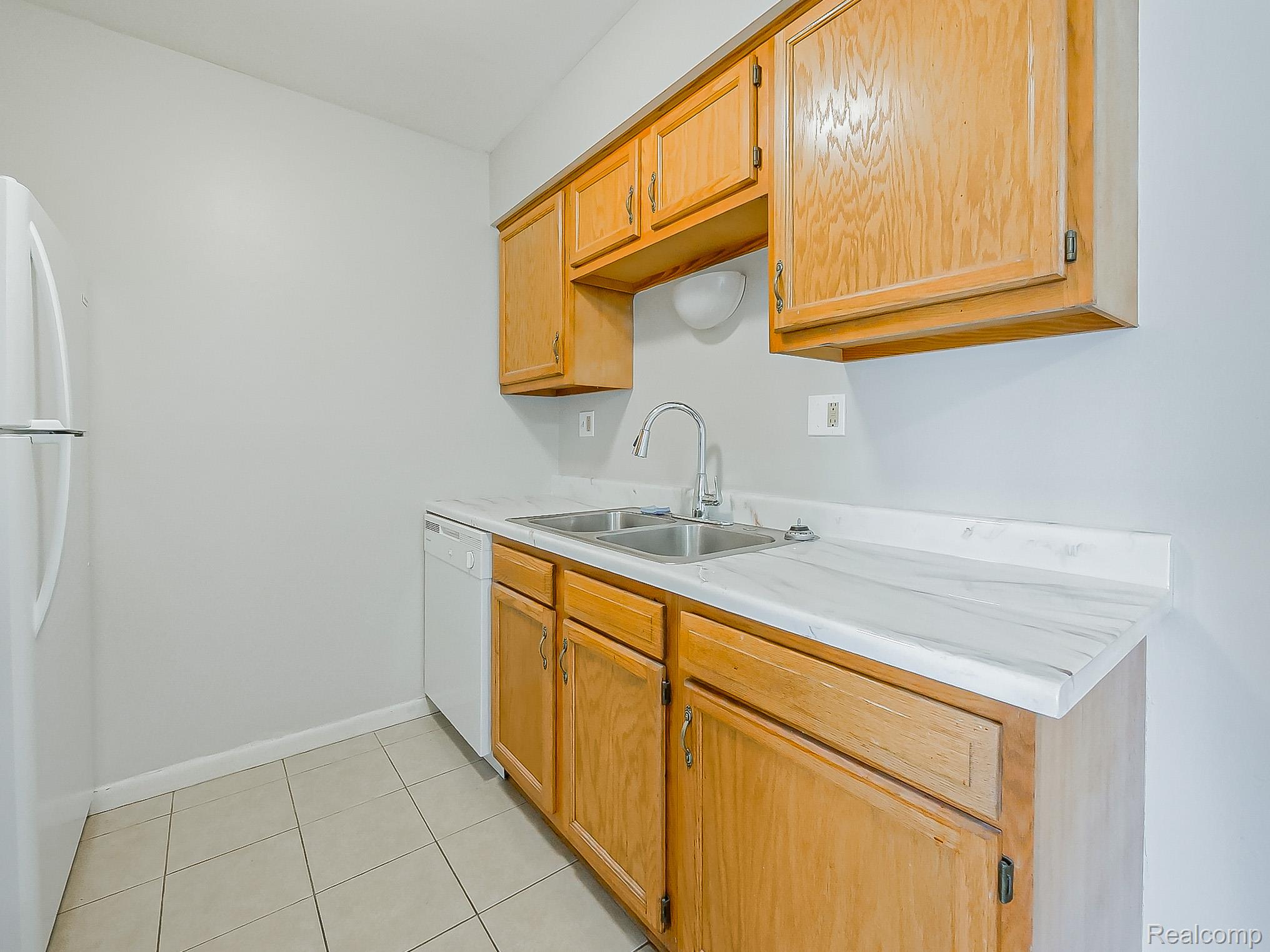 125 East Van Riper Road, Unit 5 Fowlerville, MI 48836 - Photo 9 of 23 Kitchen featuring white appliances, light countertops, and light tile patterned flooring