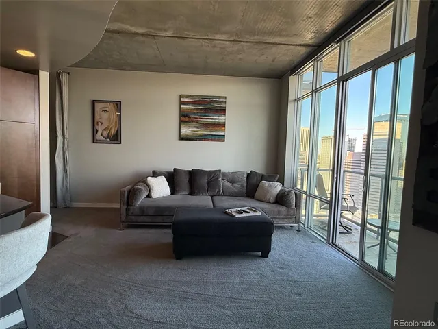 a living room with furniture and a floor to ceiling window