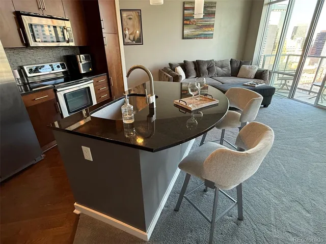 a living room with couches chairs and a dining table with wooden floor