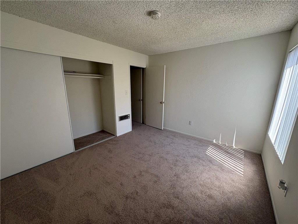 1030 West MacArthur Boulevard, Unit 116 Santa Ana, CA 92707 - Photo 9 of 15 an empty room with closet and windows