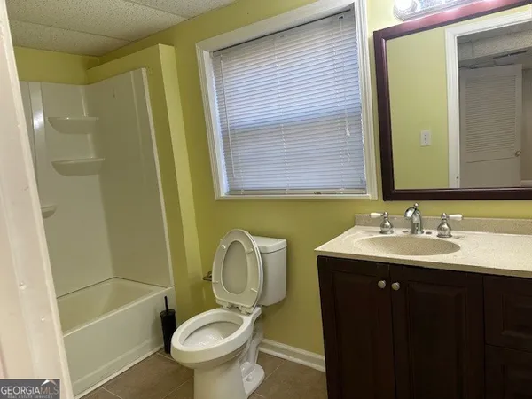 a bathroom with a granite countertop sink and a window