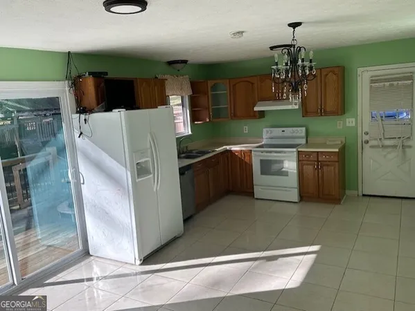 a kitchen with stainless steel appliances granite countertop a refrigerator a sink and a stove