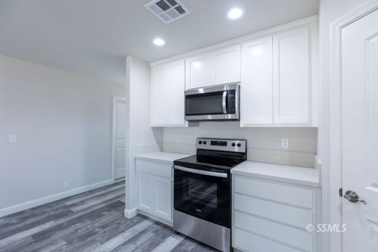 1012 Sims Street Ridgecrest, CA 93555 - Photo 12 of 36 a kitchen with a microwave stove top oven and sink