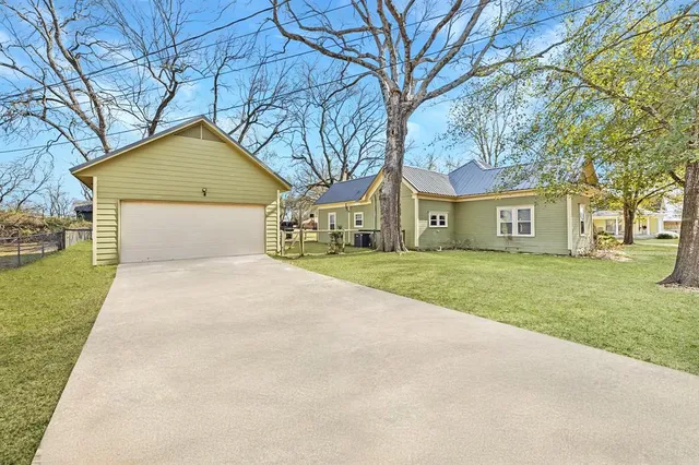 a front view of a house with a garden and trees