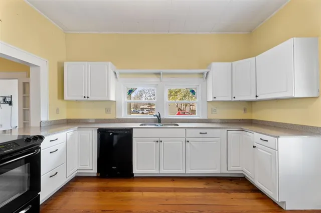 a kitchen with granite countertop white cabinets and window