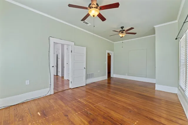 a view of empty room with wooden floor
