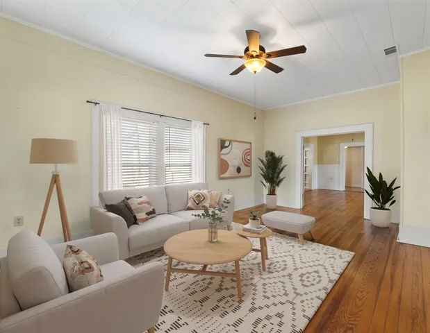 a living room with furniture and a wooden floor