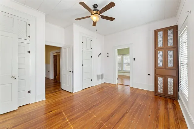 a view of a room with wooden floor and a ceiling fan