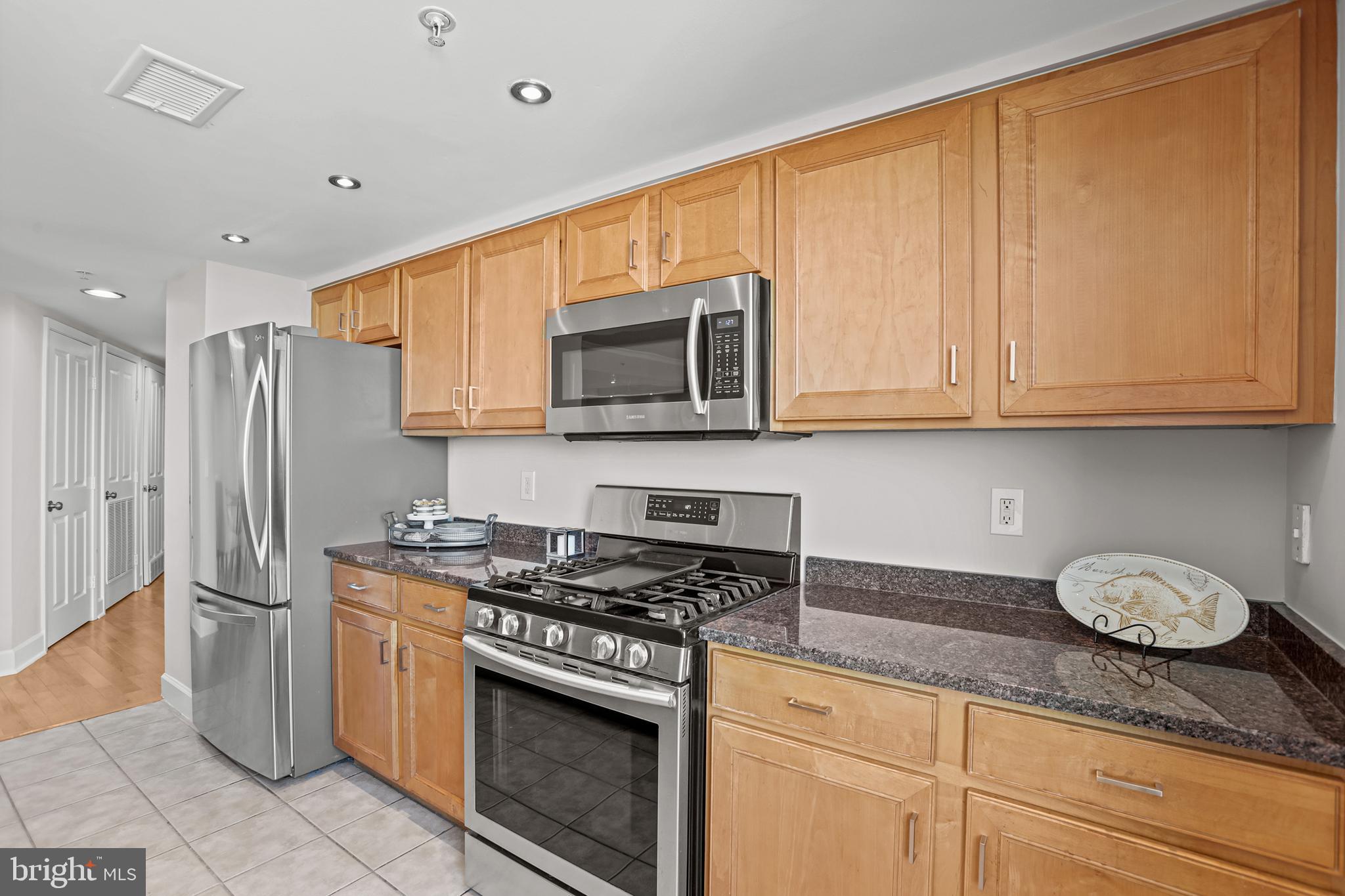 1220 North Fillmore Street, Unit 602 Arlington, VA 22201 - Photo 11 of 43 a kitchen with stainless steel appliances granite countertop a stove a sink and a microwave
