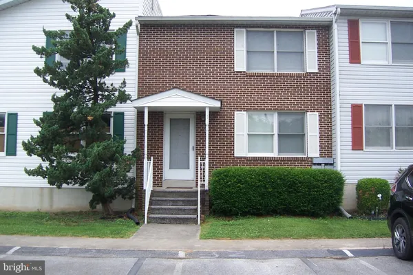 a front view of a house with plants and garden