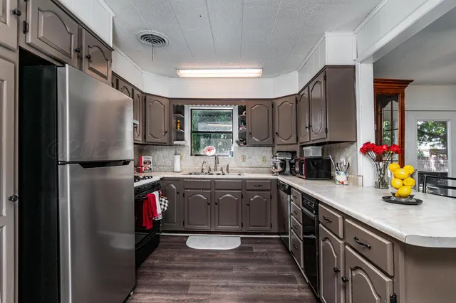 a kitchen with refrigerator and cabinets