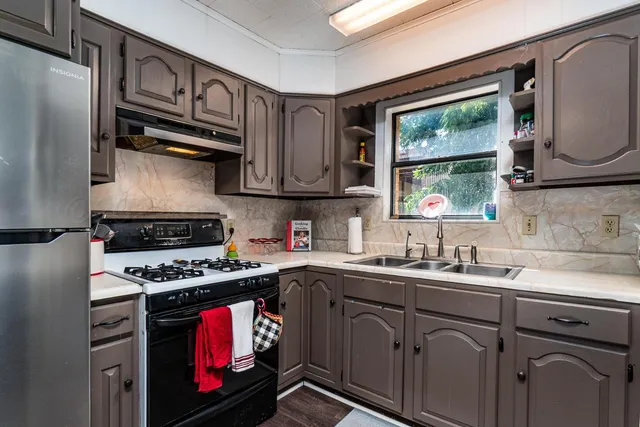 a kitchen with stainless steel appliances a stove a sink and a microwave