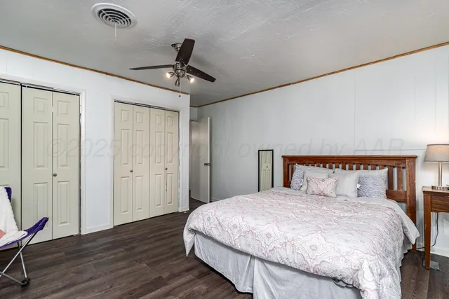 a bedroom with a large bed and wooden floor