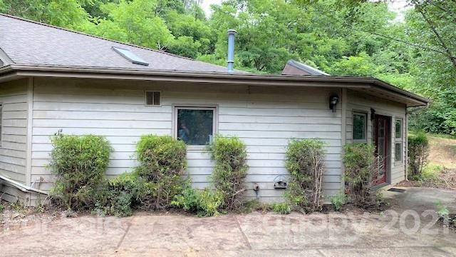 387 Spring Cove Road Waynesville, NC 28786 - Photo 4 of 48 a view of a house with a yard plants and large tree