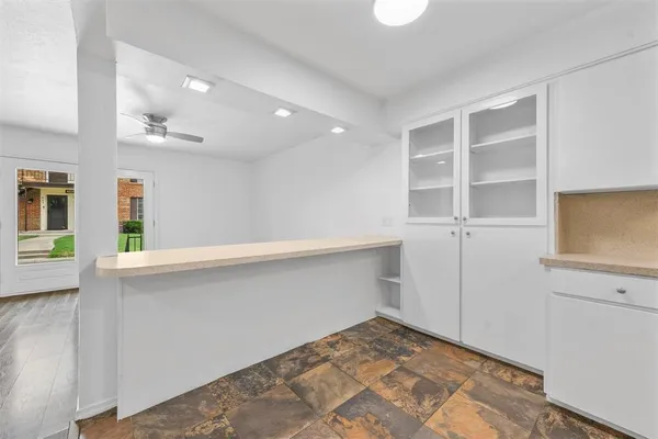 a view of an empty room with cabinet and wooden floor