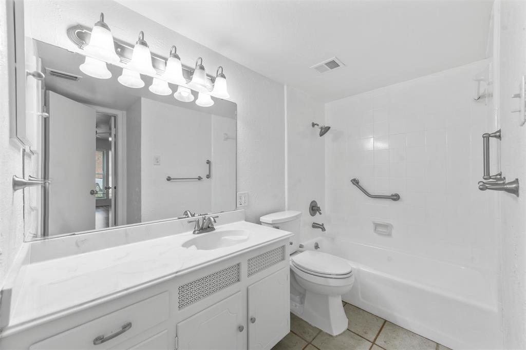 4002 Ridglea Country Club Drive Fort Worth, TX 76126 - Photo 20 of 36 a bathroom with a toilet a sink a tub and a mirror