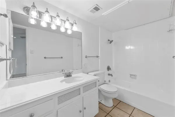 a bathroom with a toilet a sink a mirror and a shower