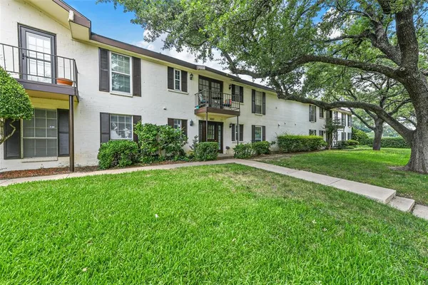 a front view of a house with a yard and potted plants