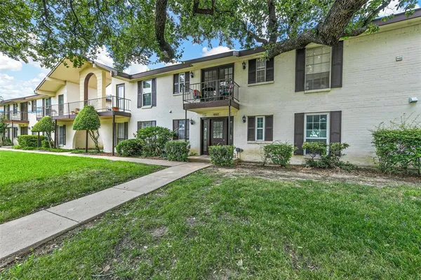 a front view of a house with a yard and trees