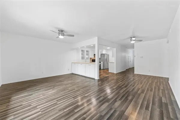 a view of a livingroom with a kitchen counter tops and wooden floor