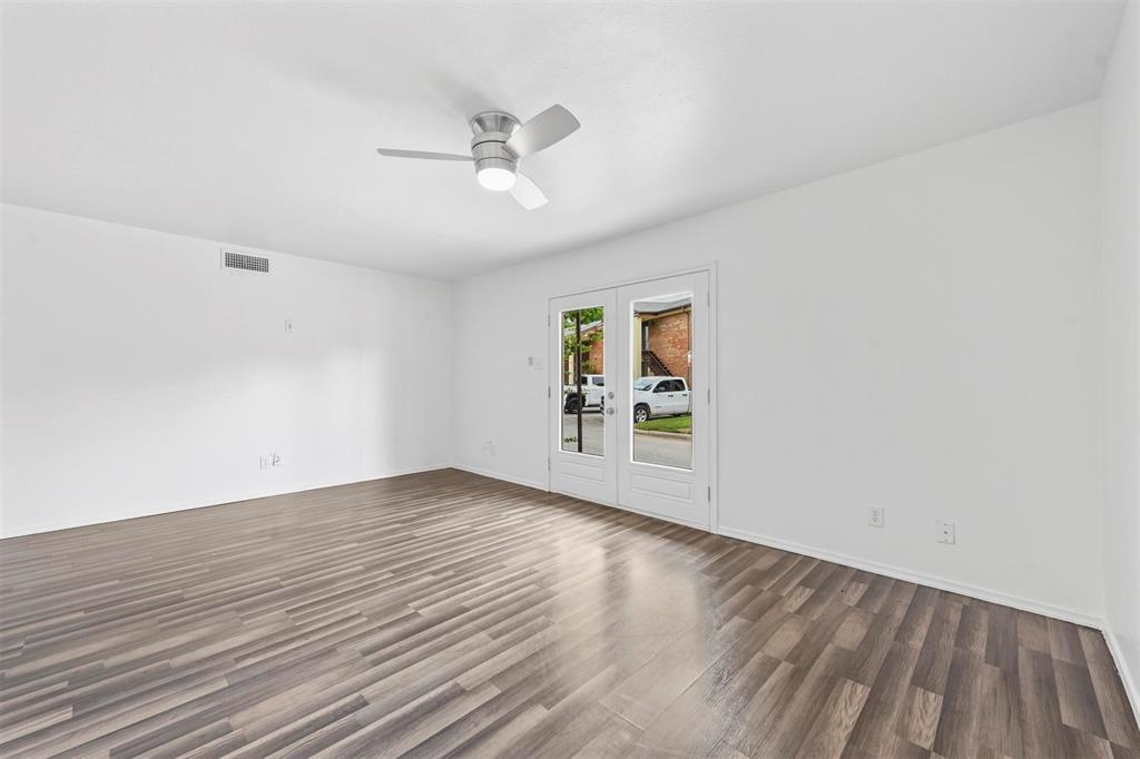 4002 Ridglea Country Club Drive Fort Worth, TX 76126 - Photo 6 of 36 an empty room with wooden floor chandelier fan and windows