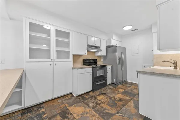 a kitchen with a refrigerator sink and cabinets