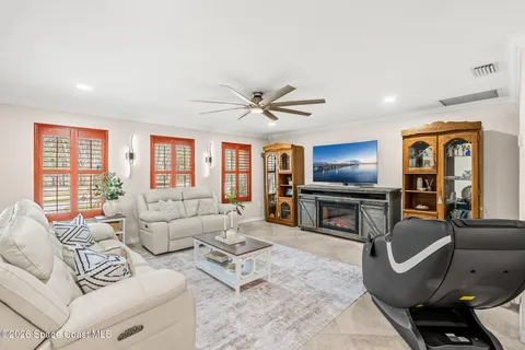 a living room with furniture a fireplace and a chandelier