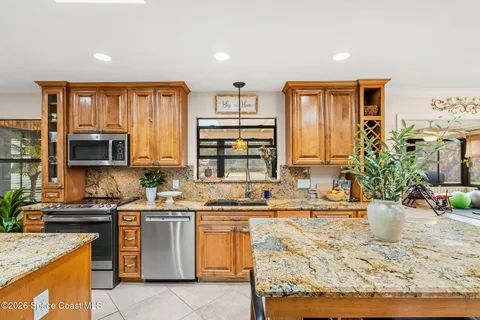 a kitchen with stainless steel appliances granite countertop a refrigerator and a stove