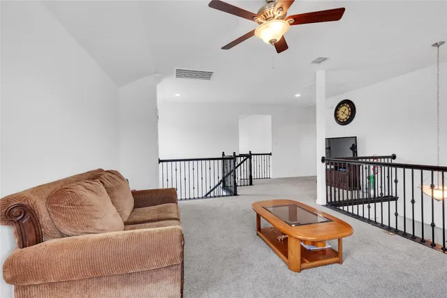 a living room with furniture ceiling fan and a rug