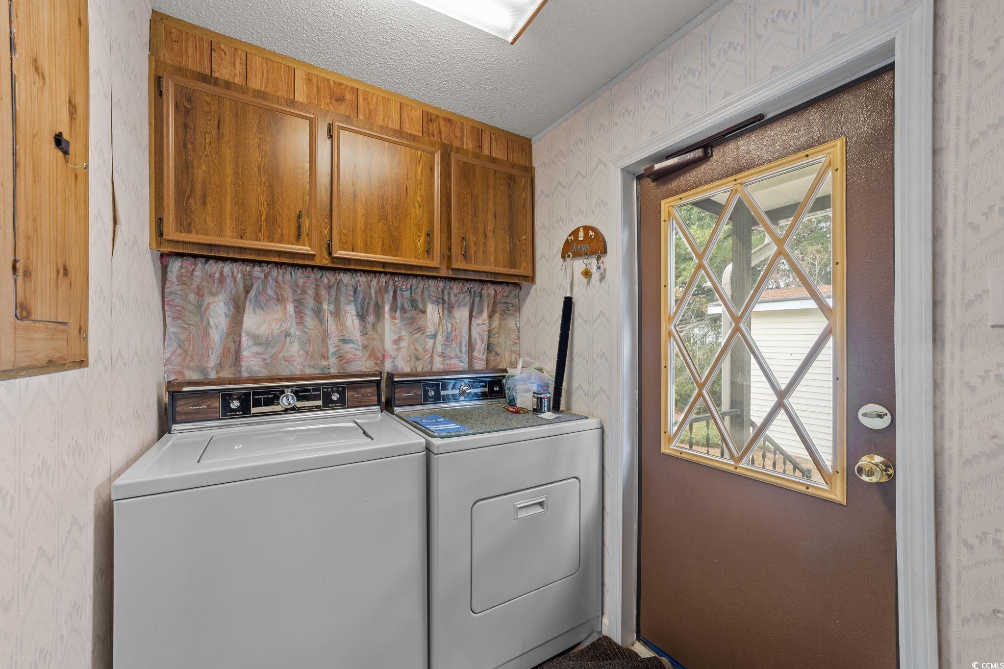 894 South Marlin Circle Murrells Inlet, SC 29576 - Photo 8 of 40 Washroom featuring wallpapered walls, washer and clothes dryer, cabinet space, and a textured ceiling