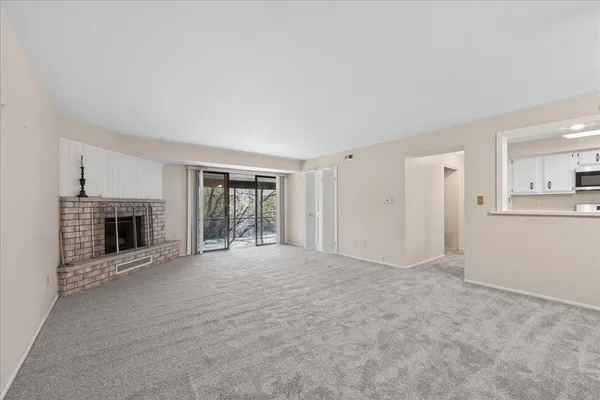 a view of an empty room with a fireplace and a window