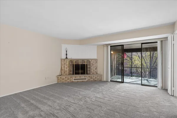 a view of an empty room with a fireplace and a window