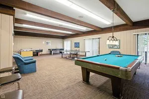 a room with pool table and windows