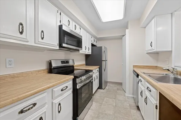 a kitchen with stainless steel appliances granite countertop a sink and a stove