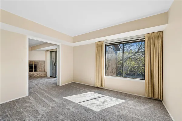 a view of an empty room with window and wooden floor