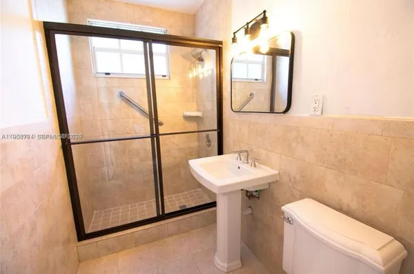 a bathroom with a sink toilet and a mirror