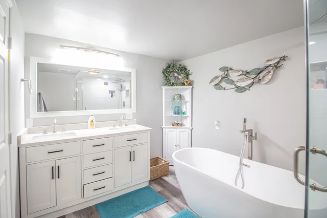 a bathroom with a tub a sink and mirror