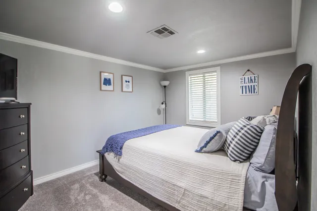 a bedroom with a bed and dresser with mirror