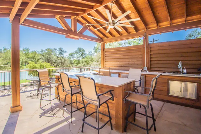 a patio with table and chairs and potted plants